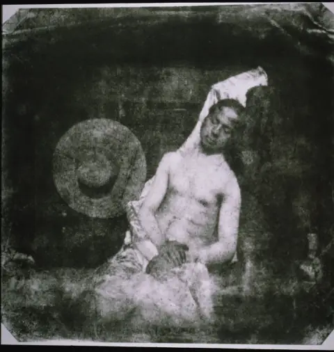 Hippolyte Bayard posed shirtless and slumped as a drowned corpse, eyes closed, hands dark, in the first staged photograph.