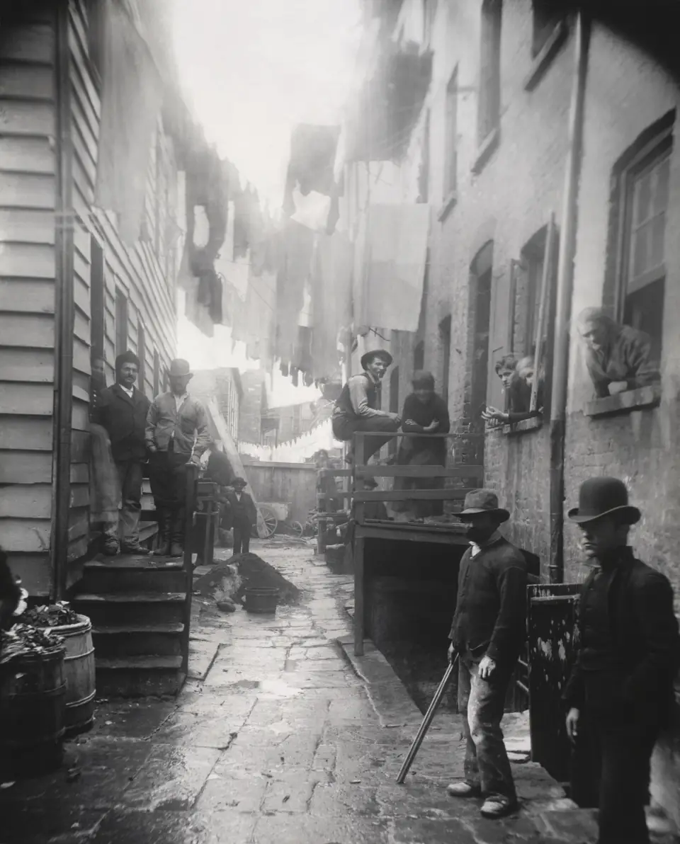 Bandit's Roost, 1888: men leaning in a narrow, laundry-strung Lower Manhattan alley, staring at the camera.