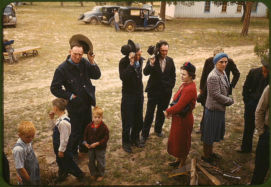 Men and women bowing their heads to say grace around an outdoor table at a 1940 New Mexico fair.
