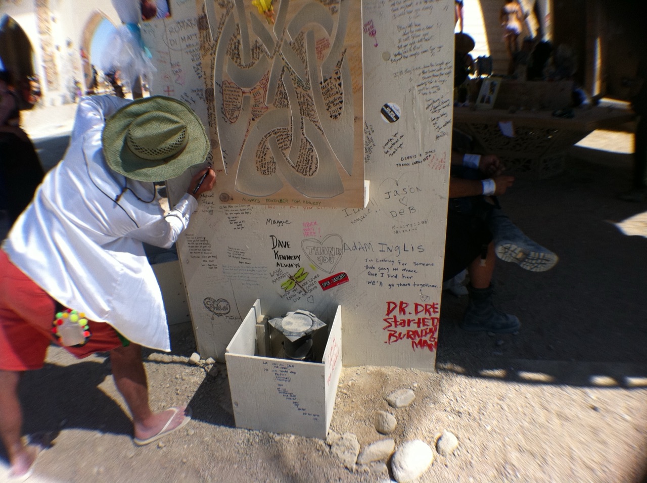 A wooden wall inside the Burning Man Temple densely covered with handwritten messages, photographs, and notes left for the dead.