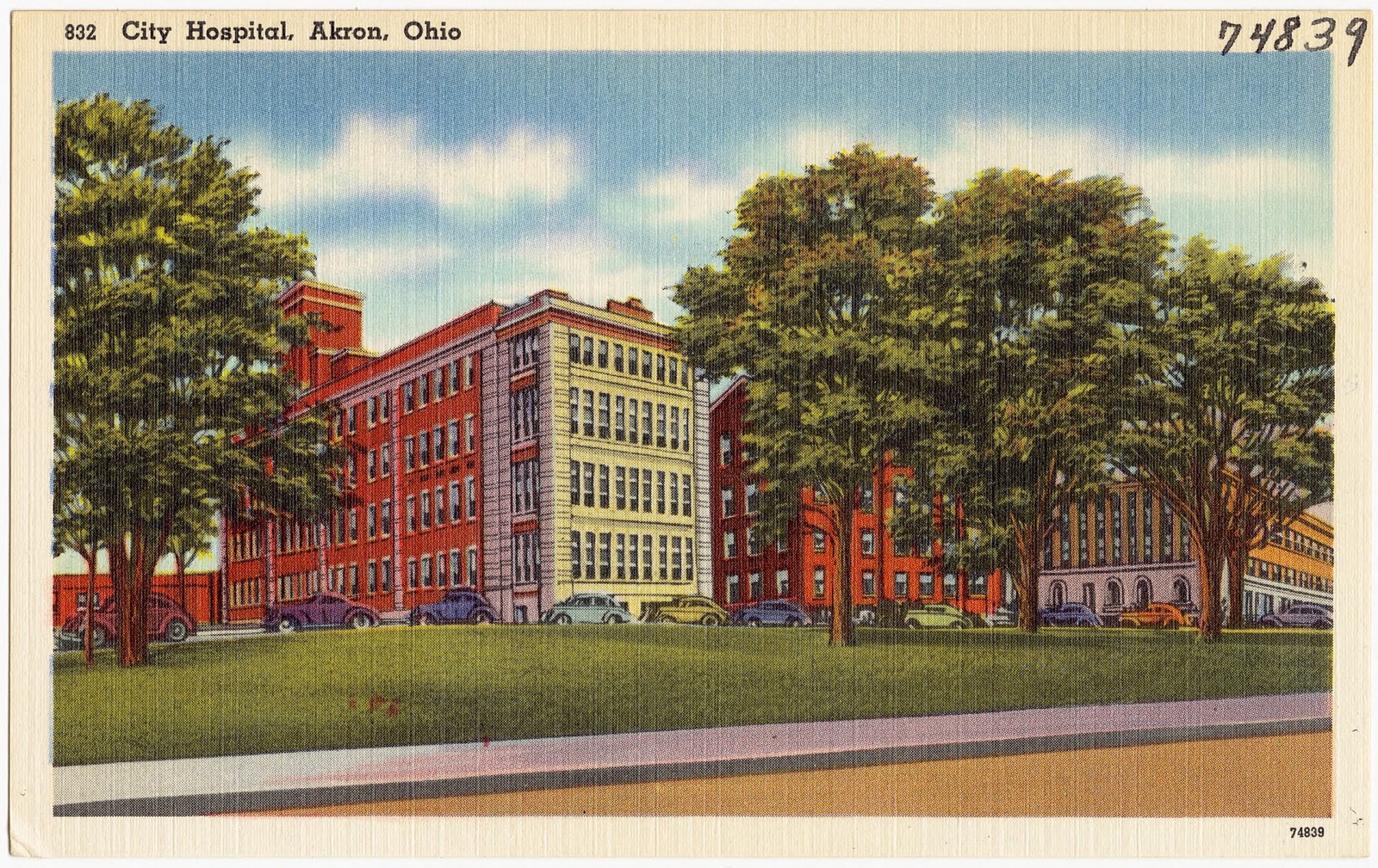 A linen postcard of the multistory City Hospital in Akron, Ohio, with lawns in front.