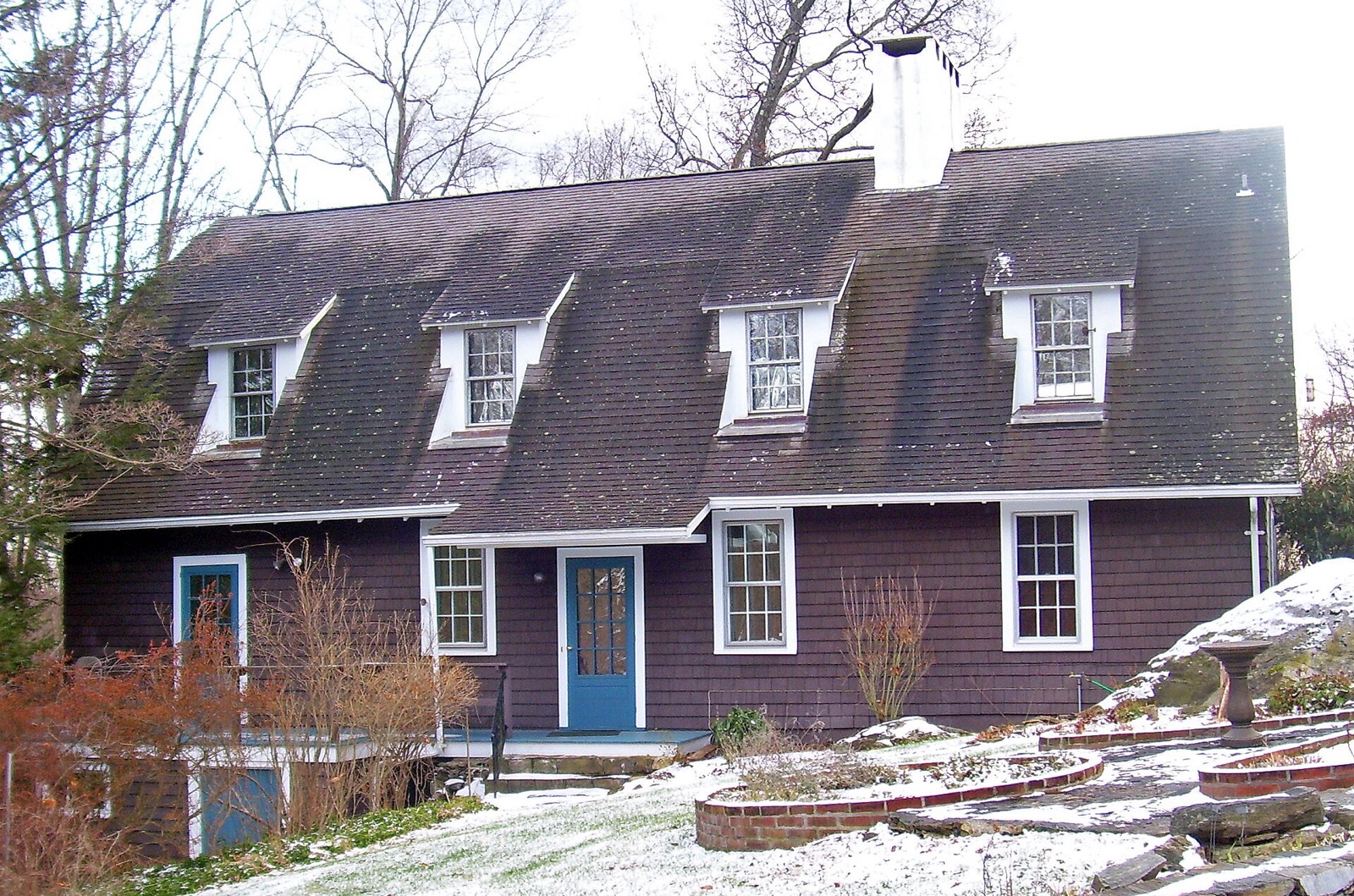 Stepping Stones, a brown shingled house among bare winter trees in Katonah, New York.