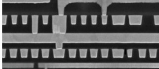A scanning-electron cross-section showing several stacked layers of metal wiring and the vias connecting them.