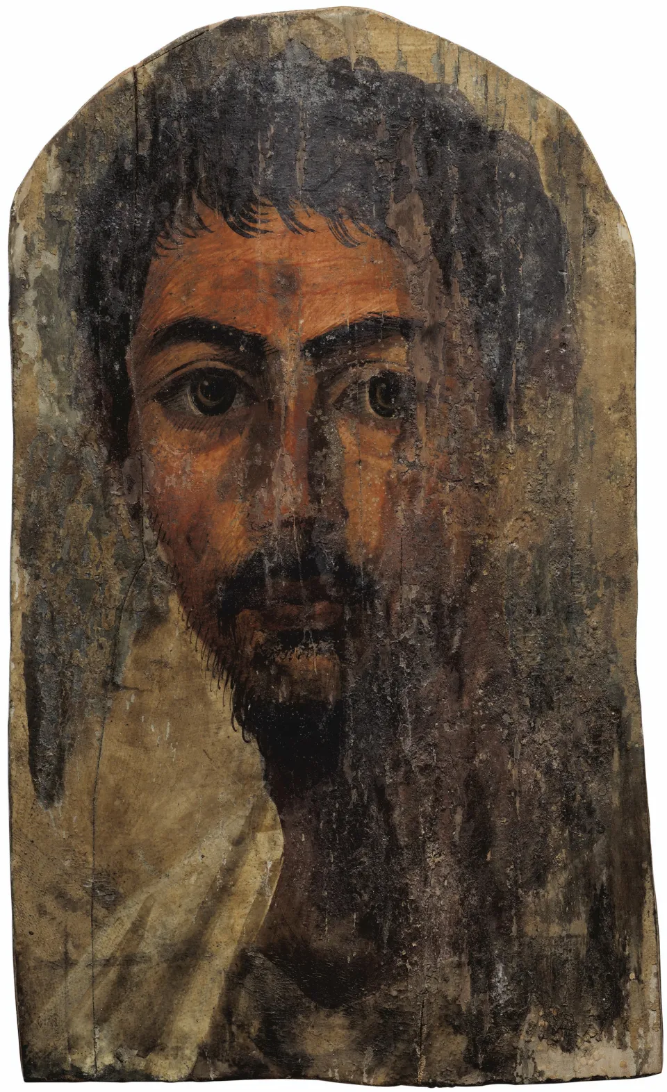 A Fayum mummy portrait: a bearded young man of Roman-era Egypt, painted on a wooden panel, looking directly out at the viewer with dark, present eyes.