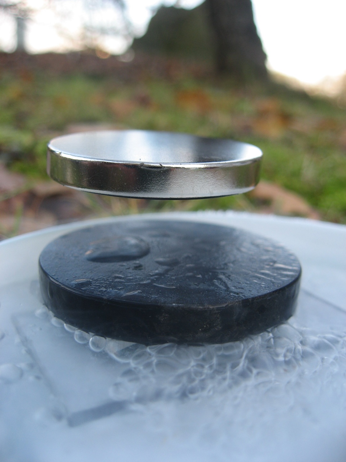 A small magnet hovering in mid-air above a superconductor cooled by liquid nitrogen, the Meissner effect.