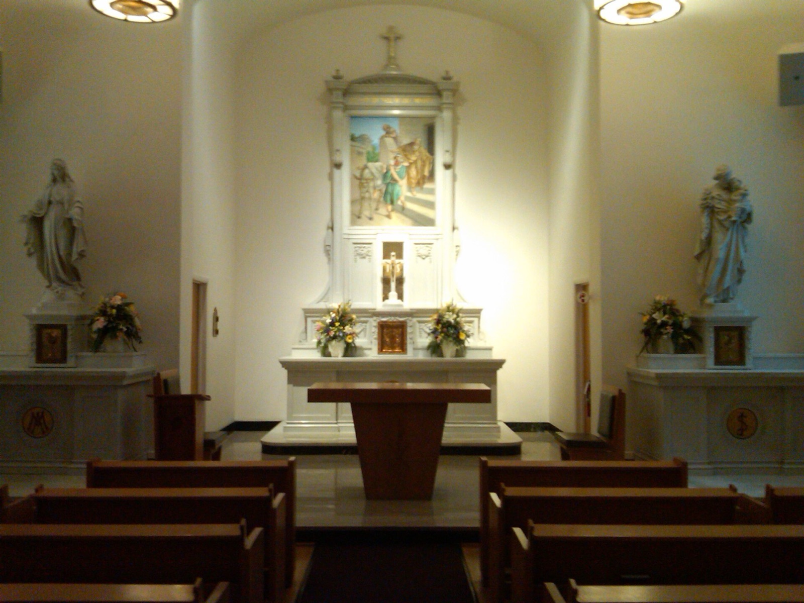 The quiet interior chapel of St. Thomas Hospital in Akron, with pews and stained glass.