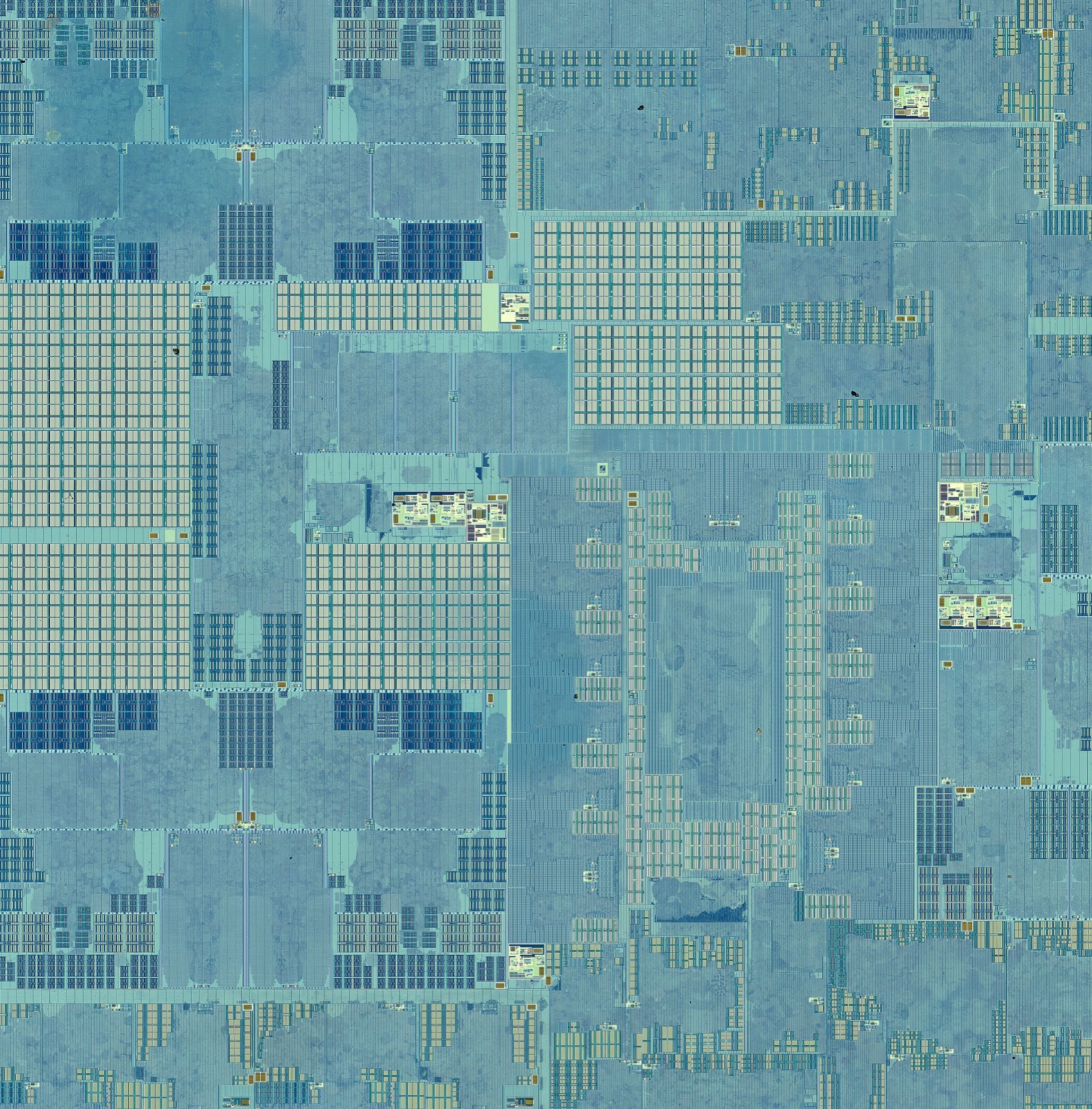 A close view of part of the M1 die, showing large functional blocks: dense regular memory arrays, structured logic blocks, and finer fabric between them.
