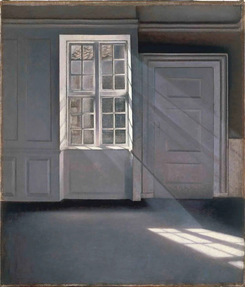 A quiet, empty room with sunlight falling through a window onto a bare floor and pale wall, dust drifting in the beam. Vilhelm Hammershoi, Dust Motes Dancing in the Sunlight, 1900.