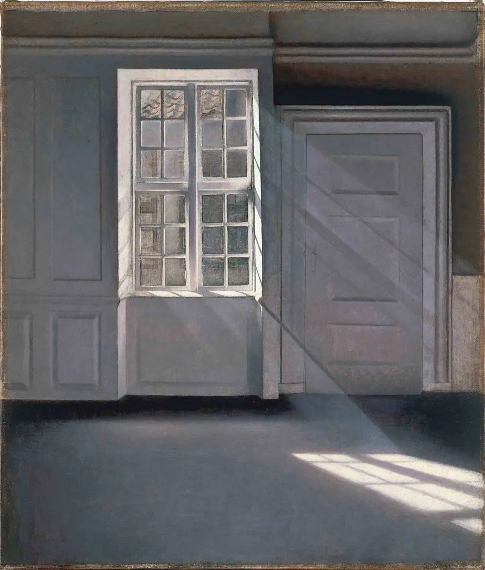 A quiet, empty room with sunlight falling through a window onto a bare floor and pale wall, dust drifting in the beam. Vilhelm Hammershoi, Dust Motes Dancing in the Sunlight, 1900.