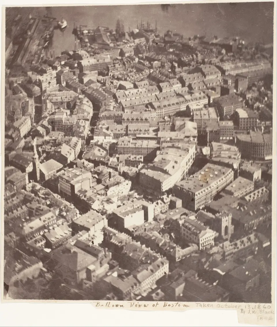 Boston from a balloon in 1860: rooftops, wharves and ships seen from twelve hundred feet, in a circular vignette.
