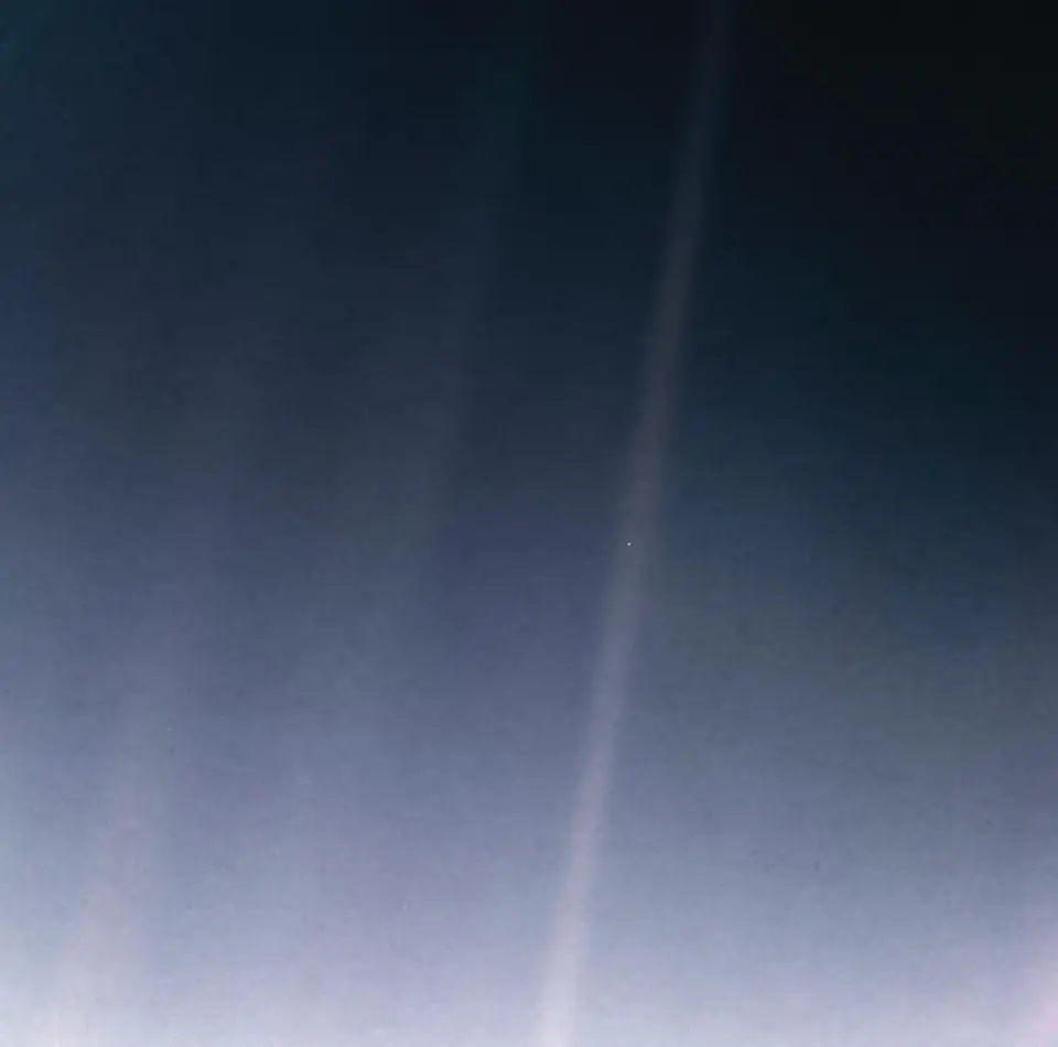 Pale Blue Dot: bands of scattered sunlight across darkness, with Earth as a single faint pale pixel suspended in one beam.