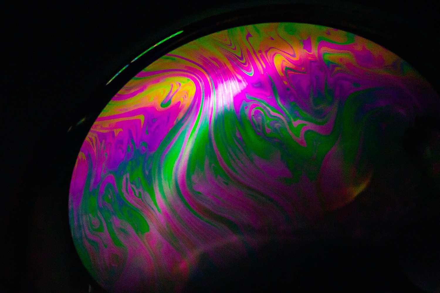 Swirling iridescent colour bands on a soap film, the shifting rainbow of thin-film interference.