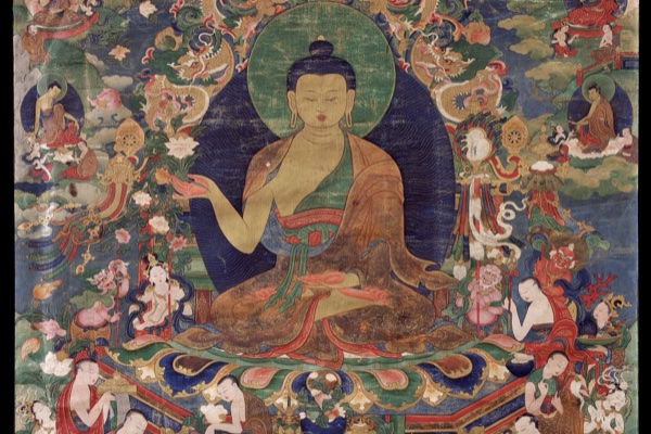 A Tibetan thangka painting: a gold-skinned Buddha seated on a lotus throne within a deep-indigo halo ringed with green, surrounded by smaller figures, dragons and clouds on a jewel-tone ground. Shakyamuni Buddha, 18th-century Tibet.