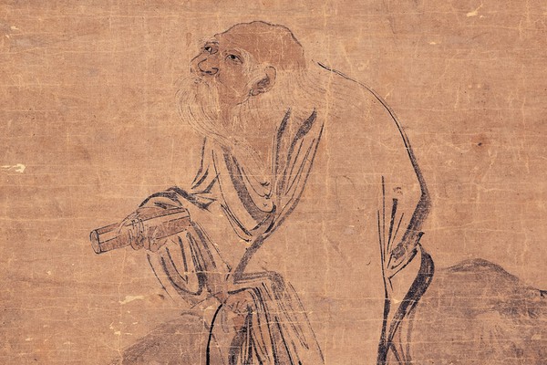 An ink painting of Laozi, a white-bearded sage holding a scroll, riding a water buffalo across aged tan silk. Zhang Lu, Ming dynasty.